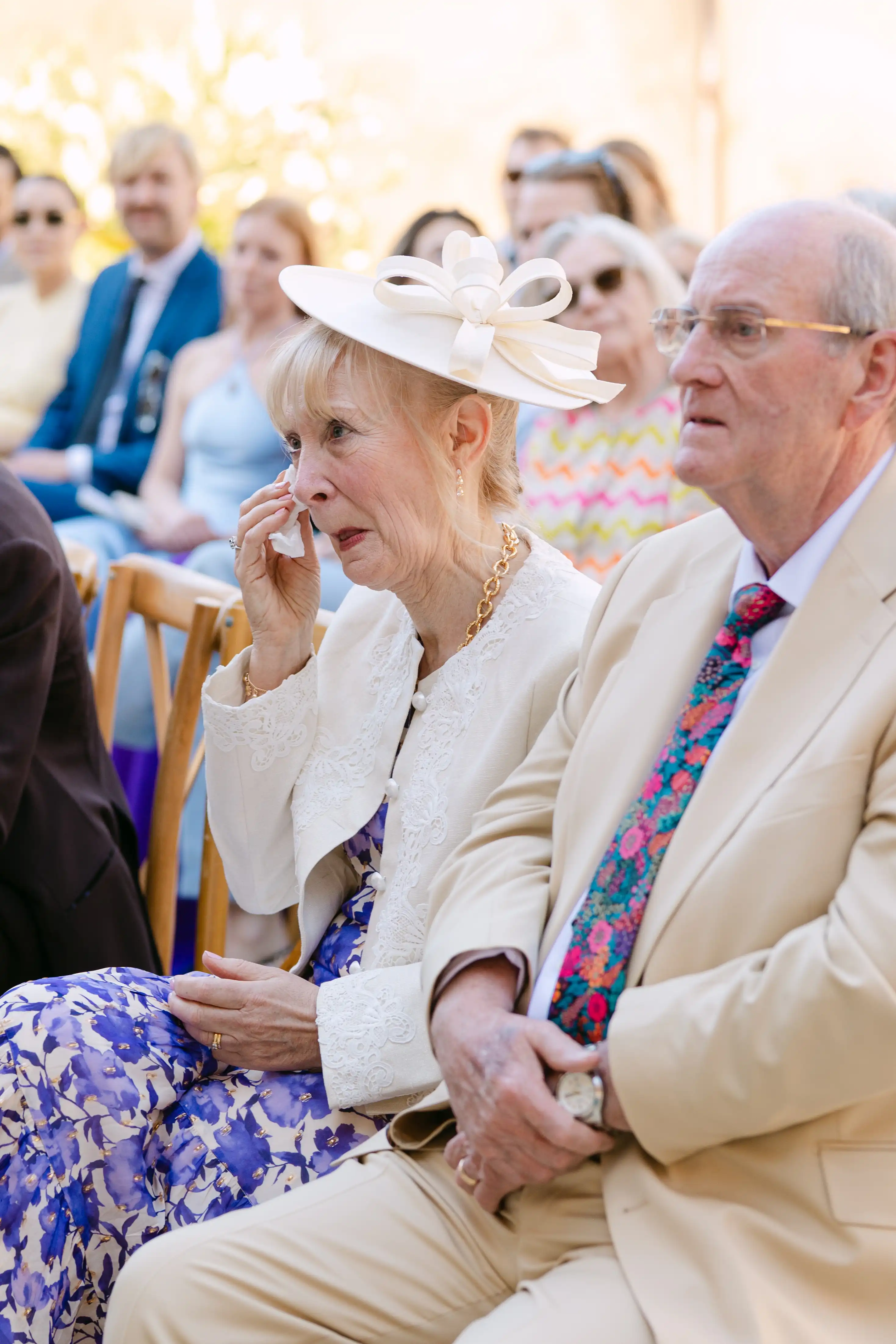 Emotional mother of the bride wiping away tears during an intimate destination wedding ceremony in Italy.